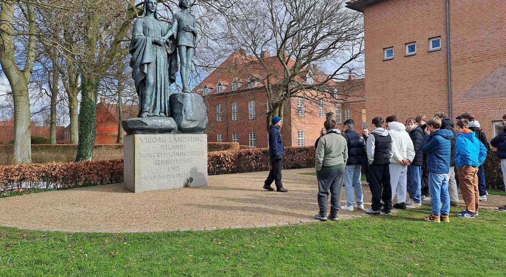 Skolegruppe på Rigets by i Midten foran kongehyldningsmonumentet